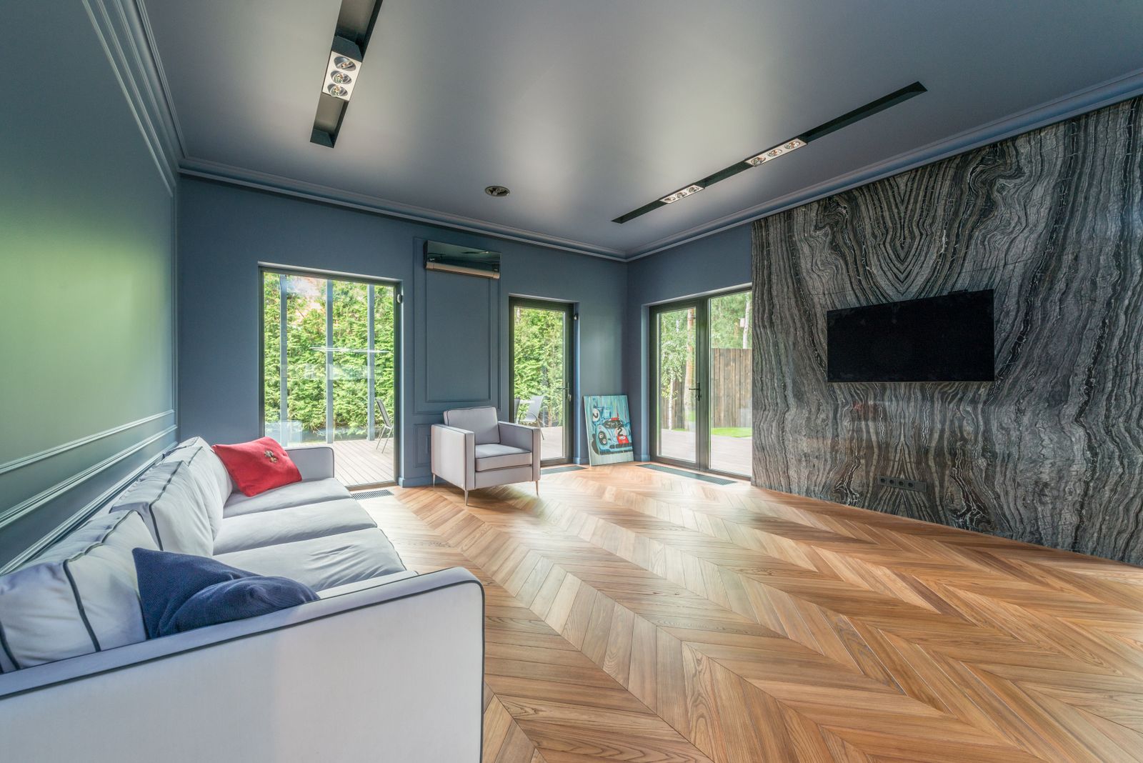 A long living room with a wall of glass doors and timber floors.